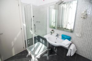 
a bathroom with a sink, mirror, and bath tub at Hotel La Colonna in Siena
