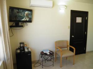a room with a chair and a tv on the wall at #52 Bungalow Seaside Hotel & Victors RV Park in San Felipe