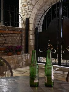 dos botellas verdes sentadas sobre una mesa en Old Town Hotel Dhermi, en Dhërmi
