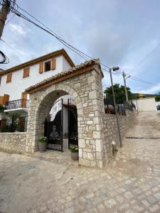 a stone building with an archway in front of a building at Old Town Hotel Dhermi in Dhërmi