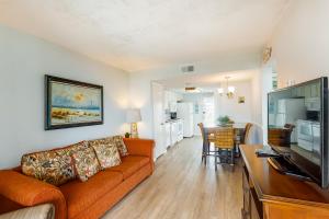a living room with a couch and a table with a television at Gulf Shores Surf & Raquet Club Condos in Gulf Shores
