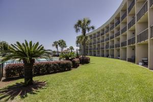 a view of the courtyard of a hotel with palm trees and grass at Pirates' Bay Marina II in Fort Walton Beach