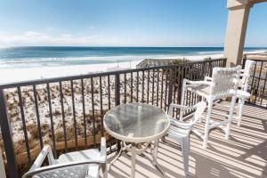 una mesa y sillas en un balcón con vistas a la playa en Emerald Towers en Fort Walton Beach