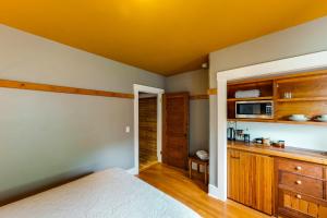 a bedroom with a bed and a kitchen with a microwave at Tacoma's Sweet Suite in Tacoma