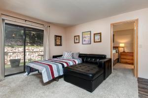 a bedroom with a bed and a couch and a window at Red Pine in Park City