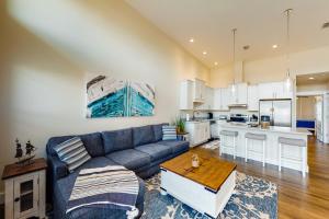 sala de estar con sofá azul y cocina en Sound Side, en Fort Walton Beach