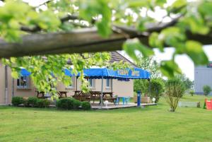 een picknickkelder met een blauwe luifel in een tuin bij Europe Hotel in Beaurepaire-en-Bresse