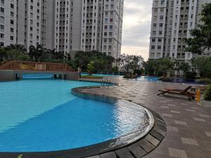 een groot zwembad in een stad met hoge gebouwen bij 2 BR Sea View 2 Big Bed 1 Sofa bed Internet Kitchen in Jakarta +7 foto's