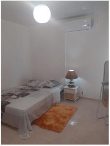 - une chambre blanche avec un lit et une lampe dans l'établissement SIMPLISSIME T4 à KOUROU, à Kourou