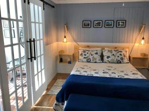1 dormitorio con 1 cama con sábanas y almohadas azules en Chez-Vous au Village, en Saint-Damien
