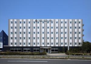 a large building with a large clock on the side of it at Tabino Hotel Kashima in Kamisu