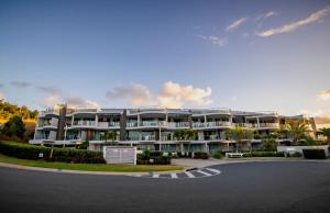 a large white apartment building with a parking lot at Marina View Apartment in Airlie Beach