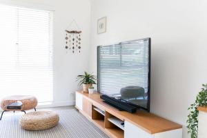 a living room with a large flat screen tv at Casa Del Mar - Seaside Family Home in Pottsville