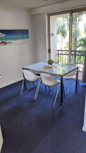 una sala de reuniones con mesa de cristal y sillas en Mermaid Beach Apartment en Gold Coast
