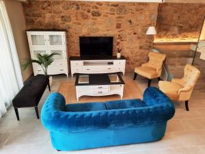 a living room with a blue couch and a tv at Solpor do Coído in Muxia