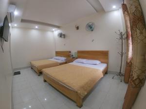 a bedroom with two beds and a tv in it at Homestay Thanh Long in Cat Ba