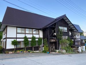 un edificio blanco y negro con techo negro en Villa Kubota, en Nozawa Onsen