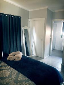 1 dormitorio con 1 cama con manta azul y espejo en Yours and Theirs Pet Friendly Accommodation, en Myrtleford