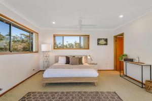 a bedroom with a bed and a window at Seascape @ 19 Pindari - privacy, space, views in Dunbogan