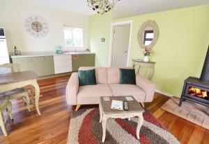 - un salon avec un canapé rose et une cheminée dans l'établissement Apple Tree Cottage Montville, à Montville