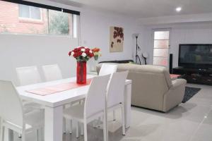 a living room with a white table and white chairs at By The Bay in Kingston Beach