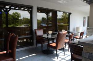 - une salle à manger avec une table, des chaises et des fenêtres dans l'établissement Baymont by Wyndham Nashville Airport, à Nashville