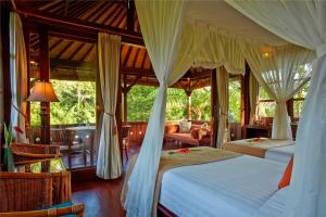 a bedroom with two beds and a living room at Bagus Jati Health & Wellbeing Retreat in Tegalalang