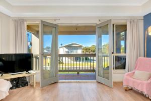 a living room with a sliding glass door to a balcony at The Lighthouse - Port Willunga - C21 SouthCoast Holidays in Port Willunga