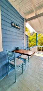 einen Holztisch und zwei Stühle auf einer Terrasse in der Unterkunft The Odyssey Resort Utila in Utila
