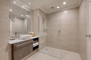 a bathroom with a tub, sink, and shower at Duxton Hotel Perth in Perth