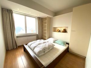 um quarto com uma cama grande e uma janela em Residentie Mercator em Oostende