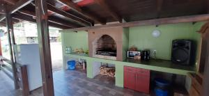 a kitchen with a fireplace in a house at Pensiunea Lorena in Cozla