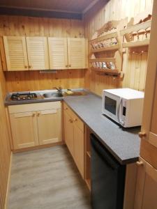 a kitchen with wooden cabinets and a microwave oven at Počitniška hiša Jurček in Žirovnica