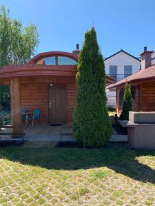 une maison avec une cabane en bois et une terrasse dans l'établissement Domek Pensjonat Syrena, à Krynica Morska