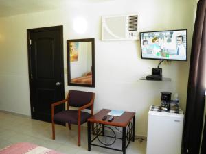 Habitación con silla, mesa y espejo. en #35 Bungalow Seaside Hotel & Victors RV Park, en San Felipe