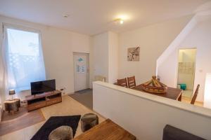 ein Wohnzimmer mit einer Treppe und einem TV in der Unterkunft 55m² 2 Zimmer-Monteurswohnung mit 4 einzelnen Betten in Nieder-Saulheim