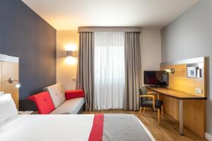 ein Hotelzimmer mit einem Bett und einem Schreibtisch in der Unterkunft Holiday Inn Express Lisbon-Oeiras, an IHG Hotel in Oeiras