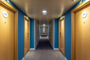un pasillo en un edificio con paredes azules y puertas de madera en Holiday Inn Express Lisbon-Oeiras, an IHG Hotel, en Oeiras