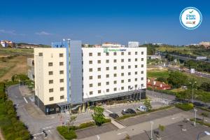 - une vue de tête sur un bâtiment blanc avec un parking dans l'établissement Holiday Inn Express Lisbon-Oeiras, an IHG Hotel, à Oeiras