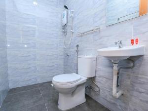 ein Bad mit einem WC, einem Waschbecken und einem Telefon in der Unterkunft OYO 89772 Roselyn Inn in Johor Bahru
