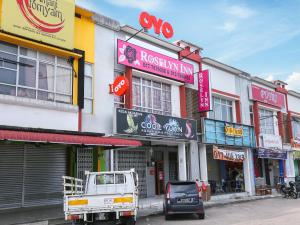 ein Gebäude mit Schildern an der Straßenseite in der Unterkunft OYO 89772 Roselyn Inn in Johor Bahru