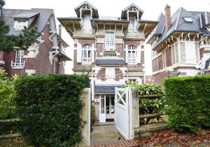 een groot huis met een witte deur ervoor bij Villa Les Cormorans, Vue Mer, 10 personnes in Ault