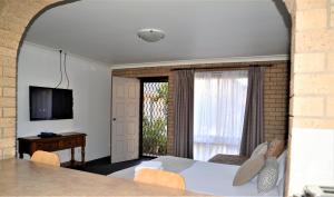 a bedroom with a bed and a television and a window at Albury Allawa Motor Inn in Albury