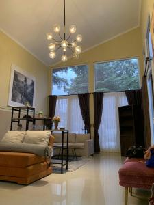 Una sala de estar con un sofá y una lámpara de araña. en Embay House & Private Pool, en Bogor