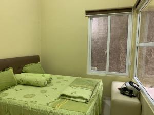 Un dormitorio con una cama y una ventana en Embay House & Private Pool, en Bogor