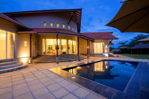 a house with a swimming pool in front of a house at Kay Jay Beach House - Pasikudha in Pasikuda