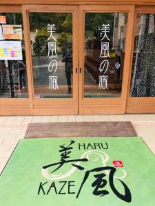 um sinal na frente de uma loja com portas em Harukaze no Yado em Iwaki