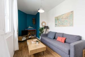 a living room with a couch and a table at Appartement 2 chambres hypercentre Saint Nazaire in Saint-Nazaire