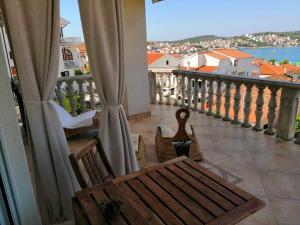 a balcony with a bench and a view of the water at Apartmani Jureta in Okrug Gornji