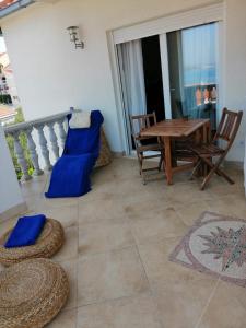 a room with a table and chairs and a balcony at Apartmani Jureta in Okrug Gornji